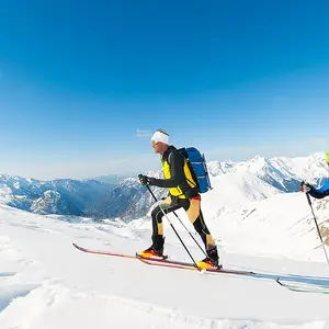 Dois homens subindo uma montanha de neve.