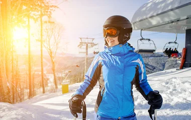 Mulher com roupa e equipamento de esquiar.