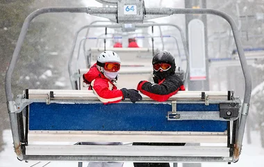 Dois esquiadores num teleférico.