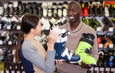 Homem escolhendo bota de esqui.