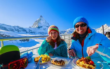 Mãe e filha comendo em restaurante com vista para a neve.