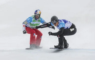 Duas pessoas praticando snowboard.