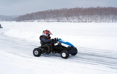 criança brincando com kart na neve