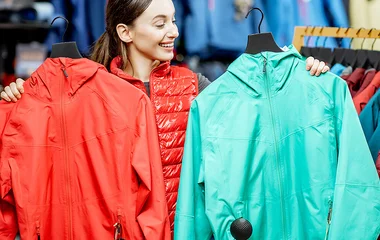 Mulher segurando duas jaquetas.