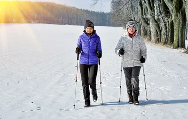 Duas mulheres fazendo caminhada nórdica.