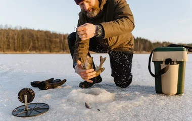 homem pescando em rio congelado