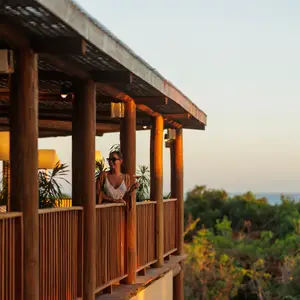 mulher em sacada tomando drink