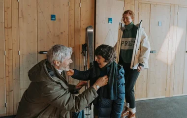 Criança, avô e mãe na estação de esqui.