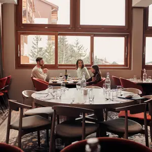 Mãe, pai e filha na mesa do restaurante, fazendo uma refeição.