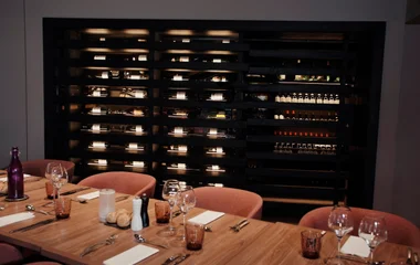 Adega de vinhos e mesas postas a frente