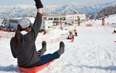 Mulher descendo uma ladeira de tobogã de plástico.