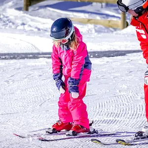 Criança e instrutora em aula de esqui em Alpe d’Huez.