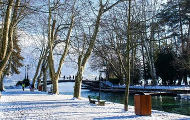 Cidade de Annecy coberta por neve em um dia de sol.