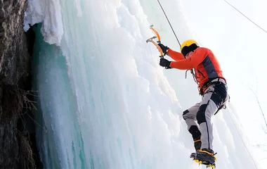 Homem praticando escalada no gelo.