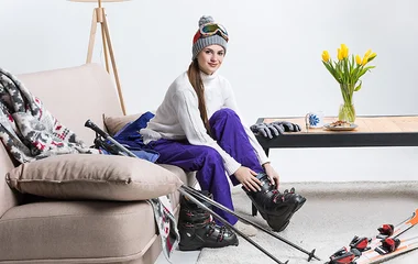 Mulher ajustando a bota de esqui.