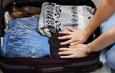 Mulher arrumando a mala de viagem.