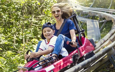 Mãe e filho descendo na montanha-russa.