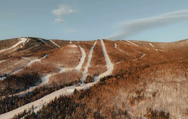 Caminhos abertos de neve em meio a floresta.