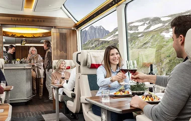 Casais no trem degustando bebidas.