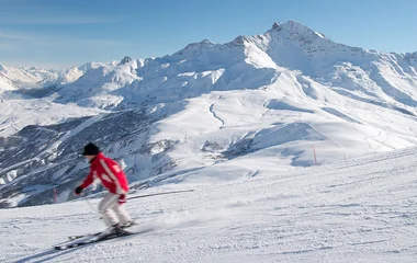 Homem esquiando em descida de montanha.