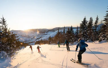 Pessoas esquiando em dia de sol.