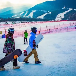 Duas pessoas carregando os equipamentos de snowboard na China.