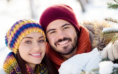 Homem e mulher lado a lado com gorro de inverno