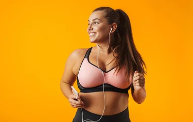 Mulher usando sutiã esportivo nas cores rosa e preto.