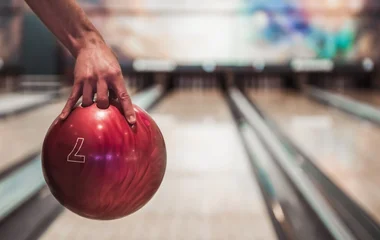 Pessoa segurando bola de boliche.