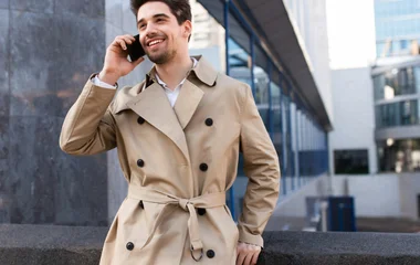 Homem usando casaco bege com botões pretos.