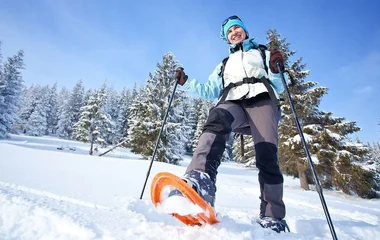 Mulher fazendo caminhada na neve.