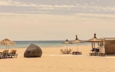 Espreguiçadeiras e guarda sol em praia