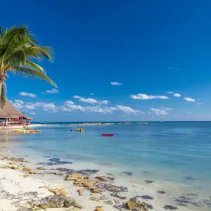 Praia no México cercada por rochas e vegetação.