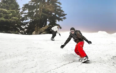 Duas pessoas praticando snowboard.