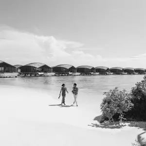 casal caminhando em praia no expaço exclusive collection
