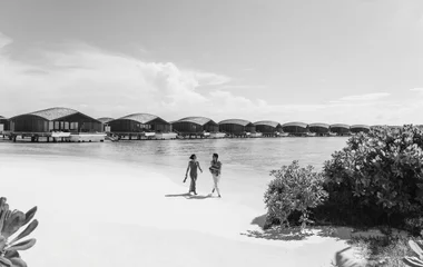 casal caminhando em praia no expaço exclusive collection