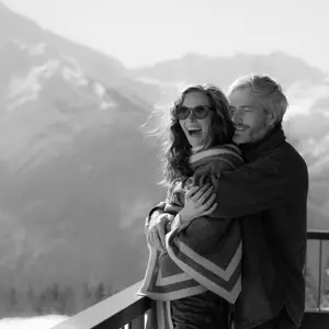 casal se abraçando com visual das montanhas cobertas de neve ao fundo