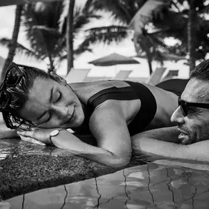 casal deitado em borda de piscina relaxando