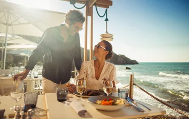 casal feliz e sorridente em mesa de restaurante