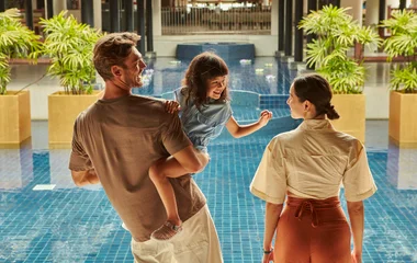 família feliz em frente a piscina