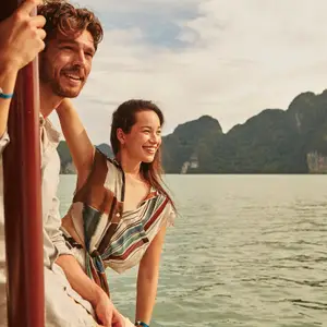 casal em barco com vista de montanhas verdes