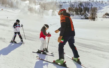Niños en clase de esquí con un instructor.