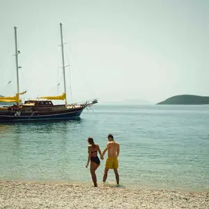 casal caminhando em praia de águas cristalinas