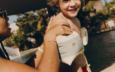 Criança na piscina com bolhinhas coloridas dentro.