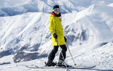 Mulher com roupas e equipamentos de esqui na neve.