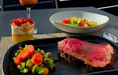 Refeição no Club Med Tignes: um prato com carne e legumes, outro com salada e uma sobremesa.