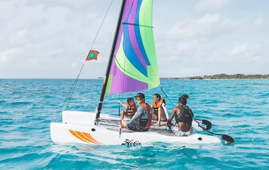 Family on a aailboat in the ocean during sunset