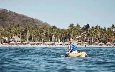 A woman enjoying sea kayaking watersport in Club Med Resort