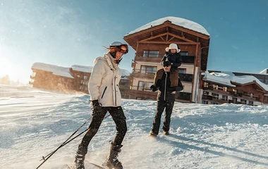 father and sone pulling sled in the Alps