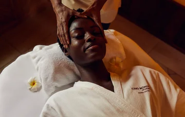 A man and a woman walking on a beach with palm trees